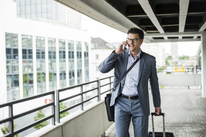 Businessman on business trip telephoning with smartphone